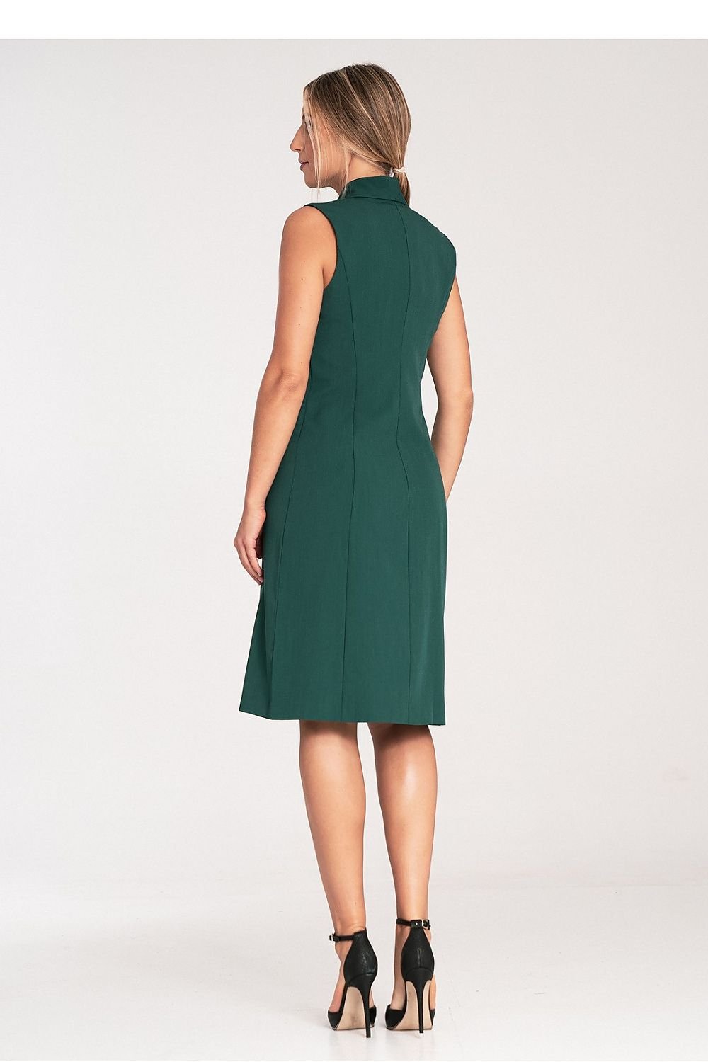 An elegant sleeveless midi dress with narrow lapels, an envelope neckline, a double-breasted closure featuring large decorative snaps, and a slightly flared hem.






