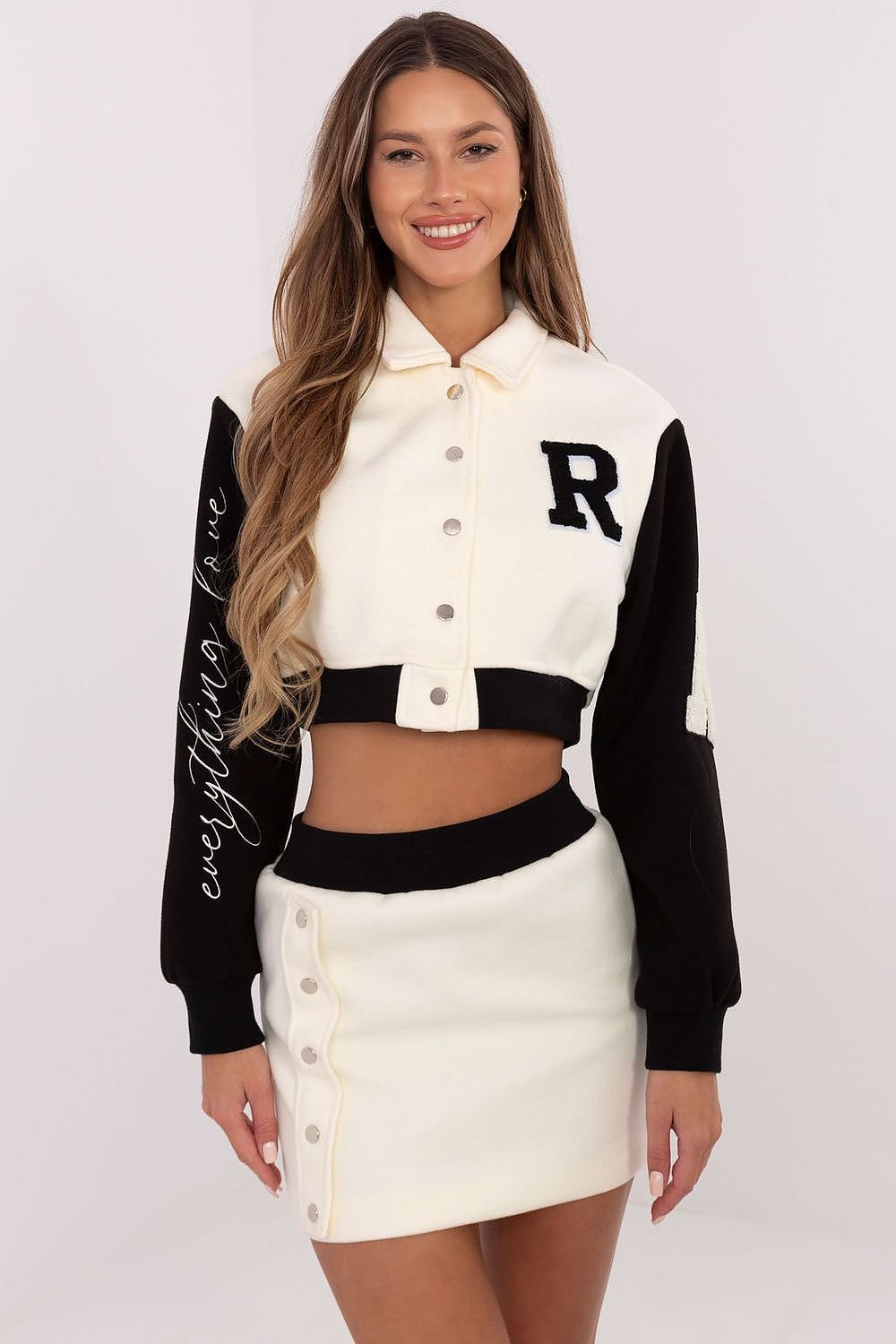  A stylish women's set featuring a short blouse with long sleeves, a stand-up collar, and press-stud closure, paired with a high-waisted skirt with an elastic waistband, offering comfort and modern style with decorative patches and embroidery.