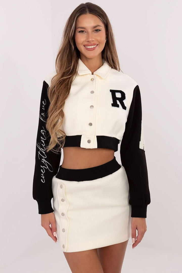  A stylish women's set featuring a short blouse with long sleeves, a stand-up collar, and press-stud closure, paired with a high-waisted skirt with an elastic waistband, offering comfort and modern style with decorative patches and embroidery.