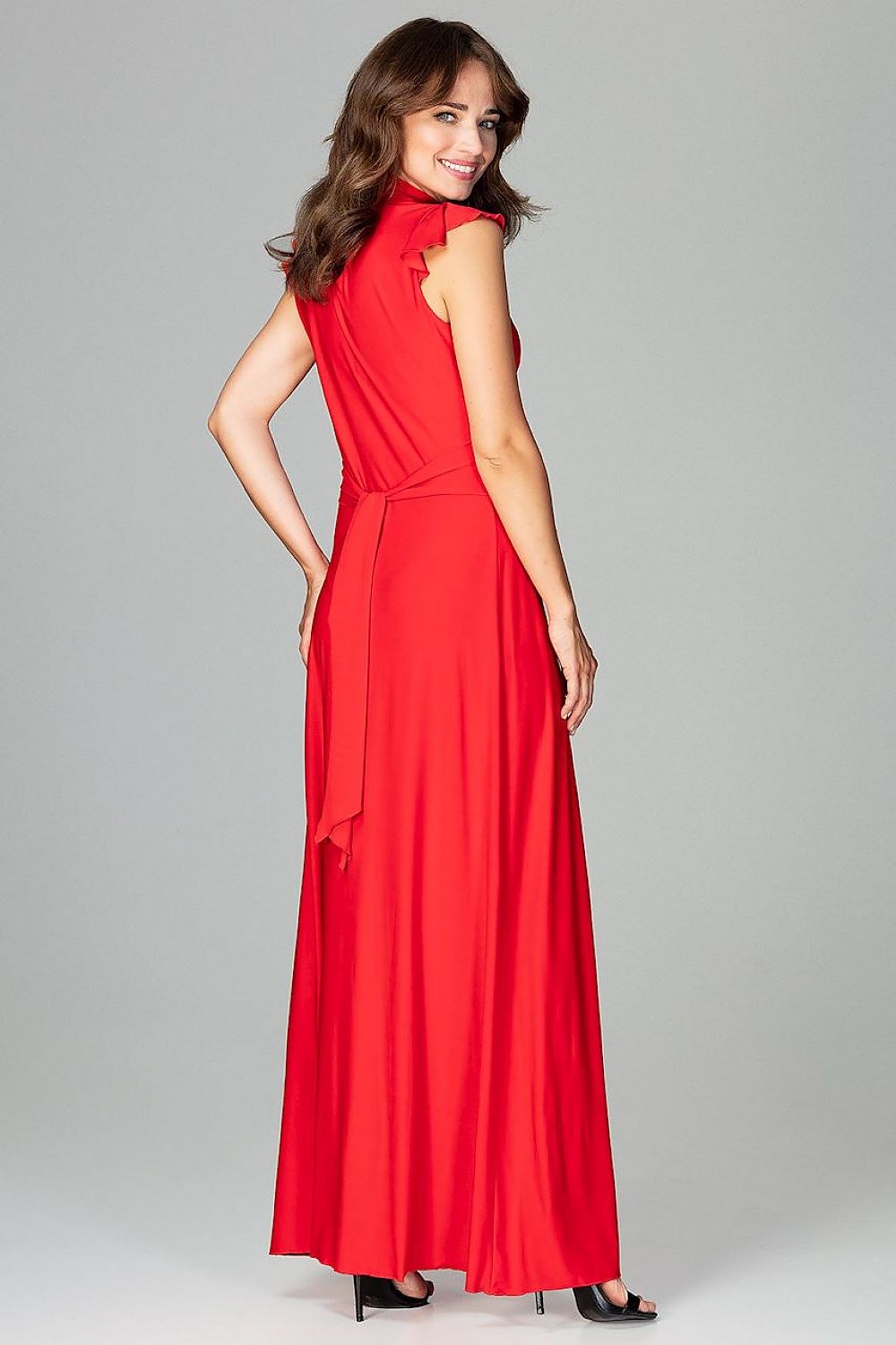 An elegant maxi dress fitted at the waist with slight flare at the bottom, featuring decorative frills on the shoulders and neckline, tied at the back, and buttoned at the top for a refined, feminine look.






