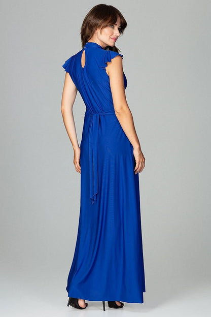 An elegant maxi dress fitted at the waist with slight flare at the bottom, featuring decorative frills on the shoulders and neckline, tied at the back, and buttoned at the top for a refined, feminine look.






