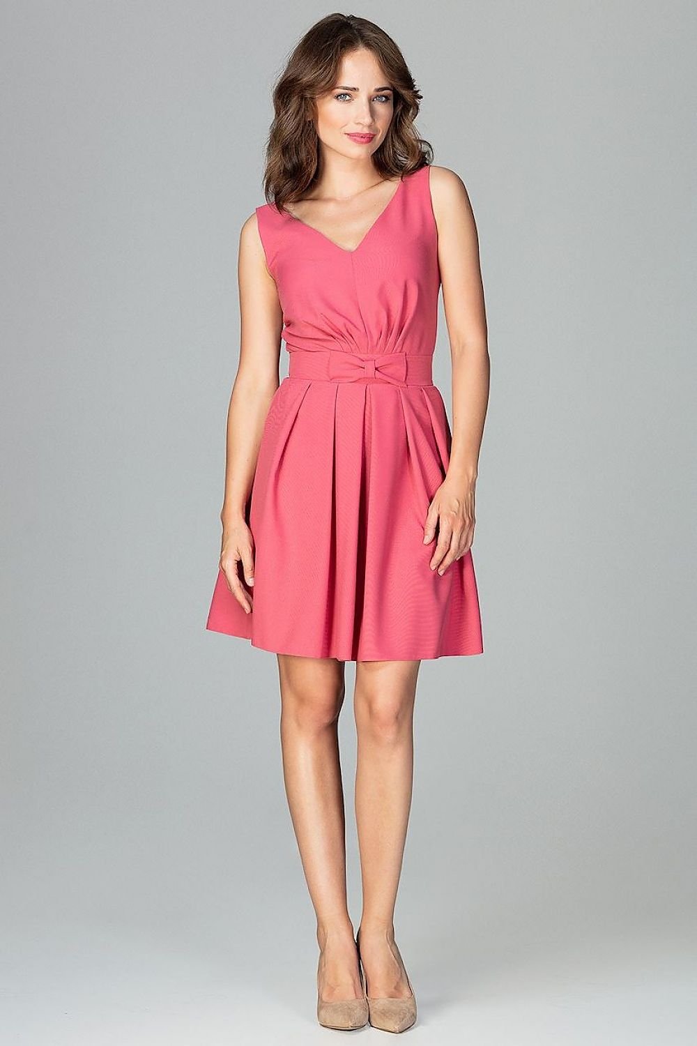 A sleeveless cocktail dress featuring a small bow at the waist, a delicate neckline, ruffles at the bottom, and a zipper, with a beautifully exposed back for a feminine and expressive look.






