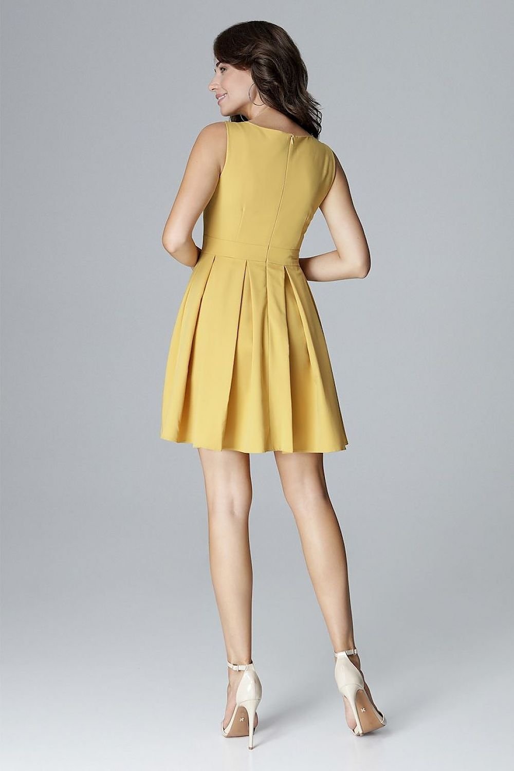 A sleeveless dress with a fitted top, low feminine neckline, and a waist-cut design with a flared bottom arranged in wide folds, perfectly emphasizing and slimming the waist.






