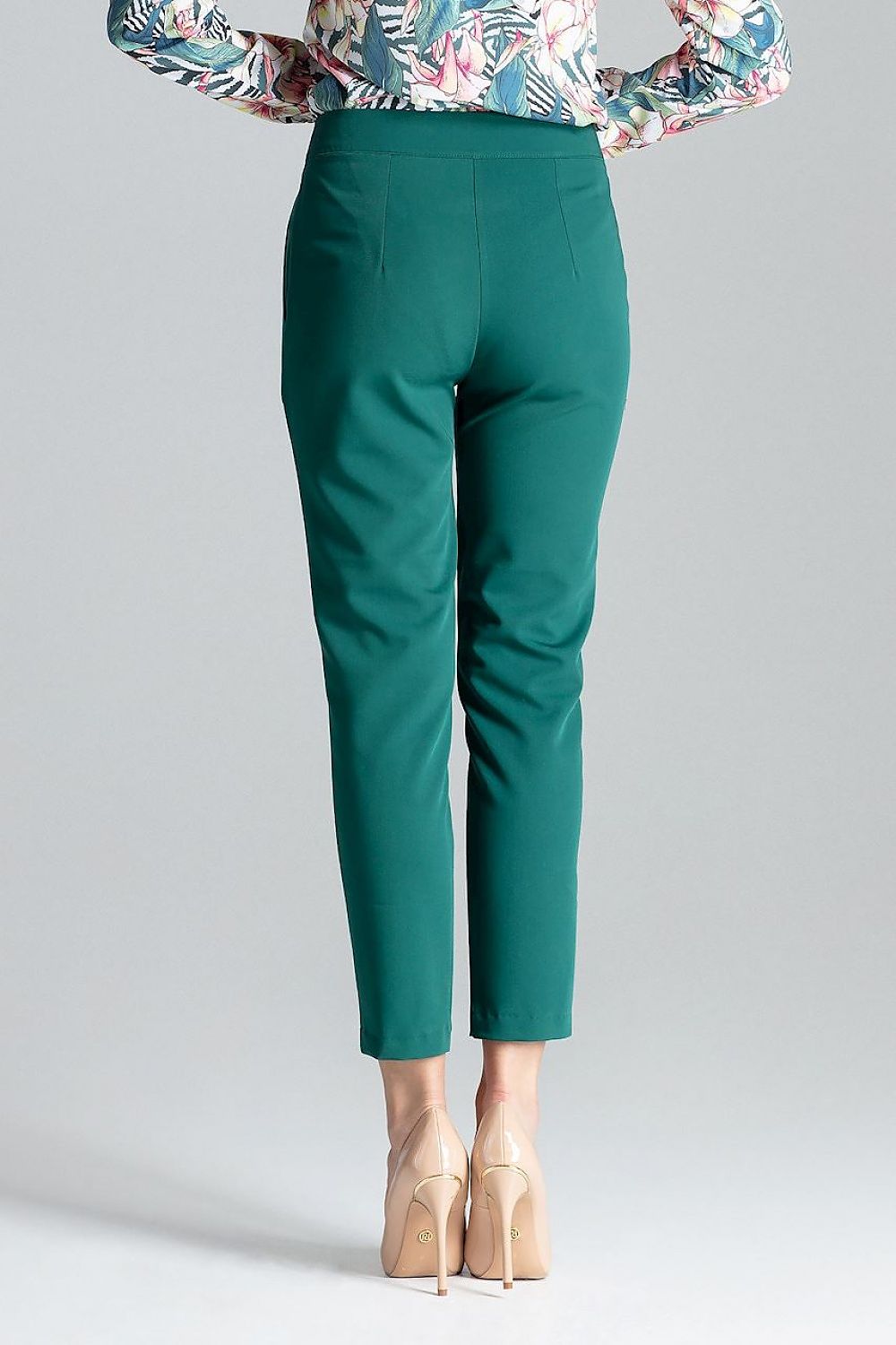 green Cigarette pants in a 7/8 length, featuring front pleats for a flattering fit and bias pockets. The model is designed with a front zipper closure for a sleek and tailored look.

