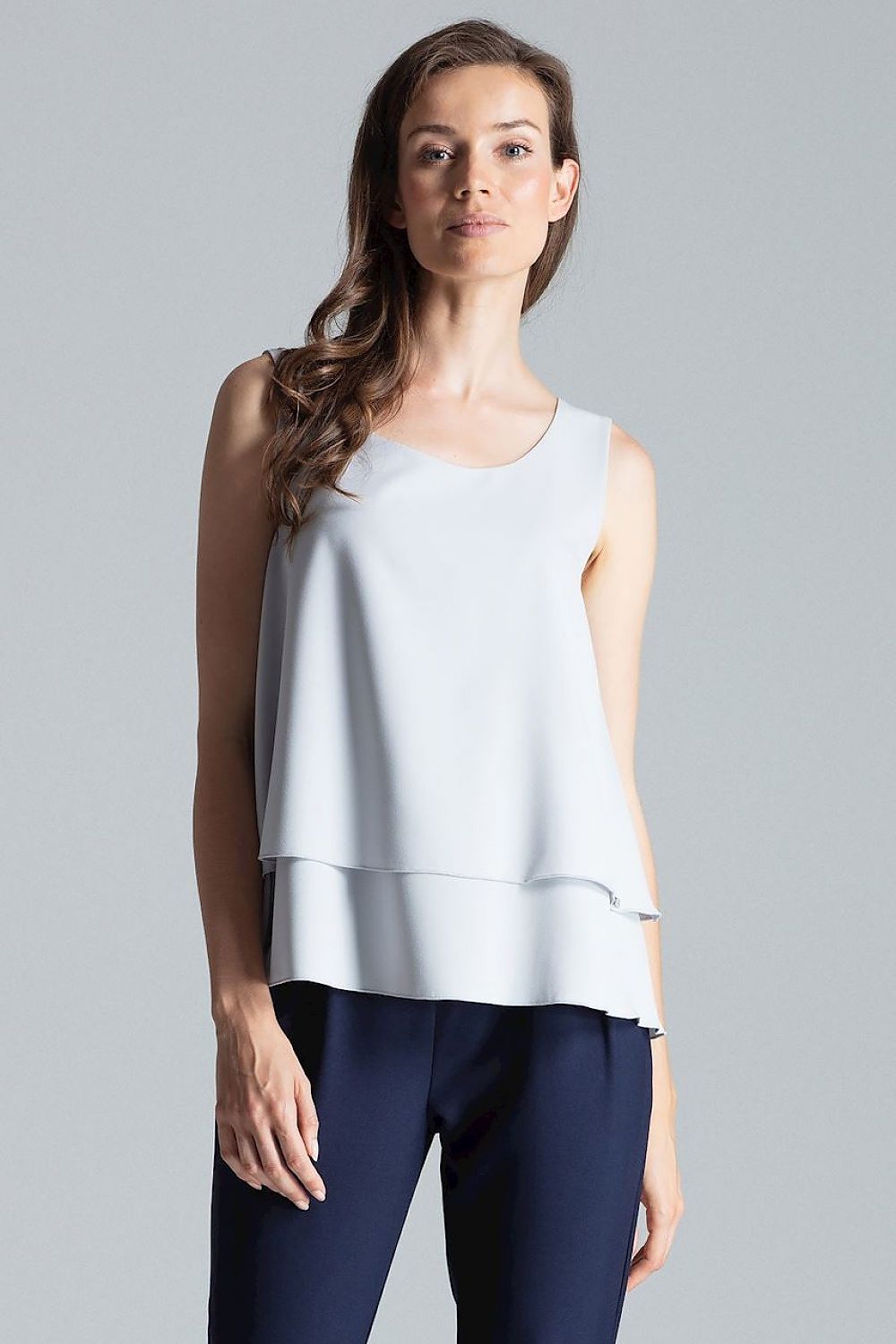 Sleeveless double-layer blouse with a patterned design, half-round neckline, and a flared bottom for a flattering fit.