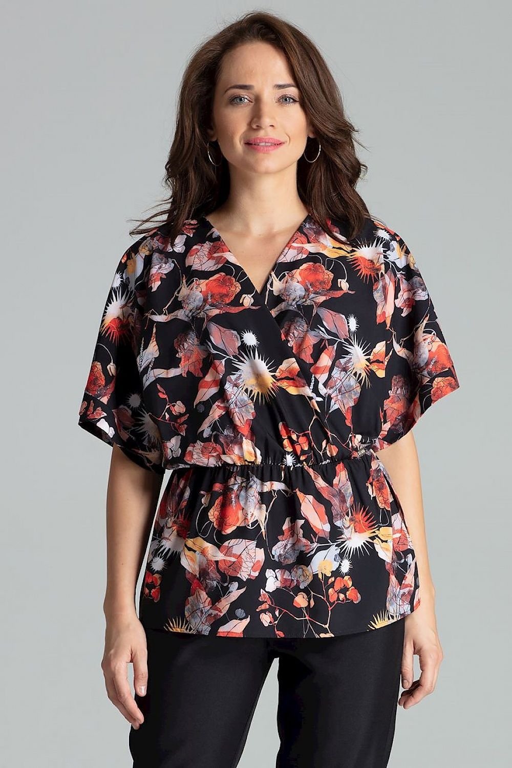 A loose-fitting floral blouse with short kimono sleeves featuring cuffed ends, an envelope neckline, and an elastic waist. The blouse falls gracefully over the hips.