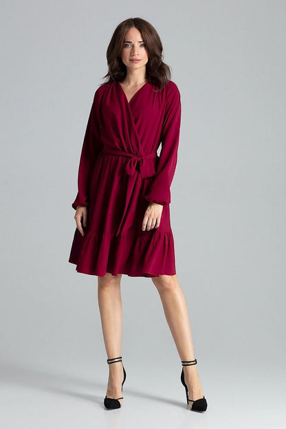 A  red midi dress featuring long sleeves with creased elastic cuffs, an envelope neckline, a frilled bottom skirt, an elastic waistband, and an additional sash to tie for a feminine silhouette.






