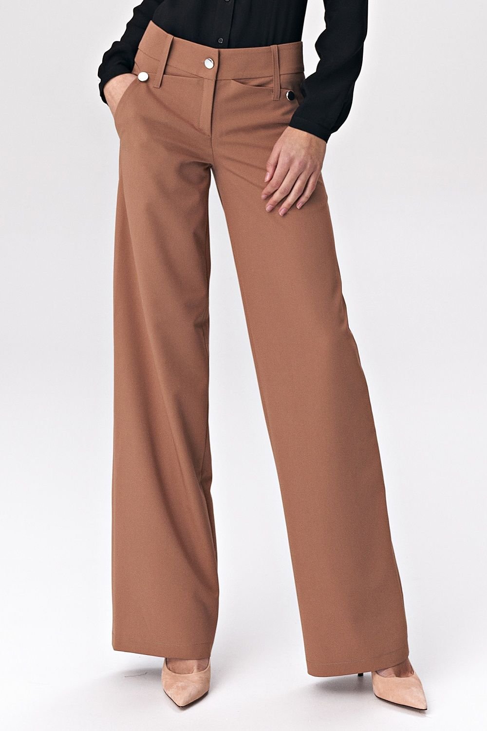 Brown women’s trousers in a fashionable palazzo cut, featuring decorative press-studs that add a modern touch to classic office styling. Made from a comfortable viscose-blend fabric, these trousers offer both elegance and high wearing comfort, perfect for soft-office style.

