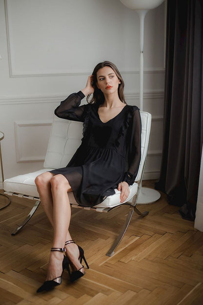 A loose-fitting flowing chiffon midi dress with long ruffled sleeves, button cuffs, a serek neckline, and decorative vertical frills on the front and back, seamed at the waist with a slip at the bottom, no fastening.






