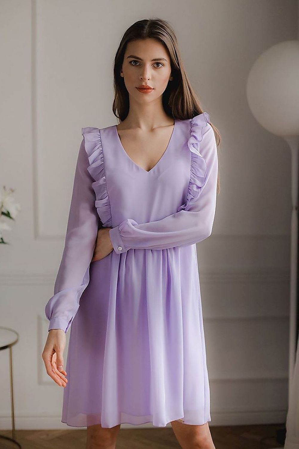 A loose-fitting flowing chiffon midi dress with long ruffled sleeves, button cuffs, a serek neckline, and decorative vertical frills on the front and back, seamed at the waist with a slip at the bottom, no fastening.






