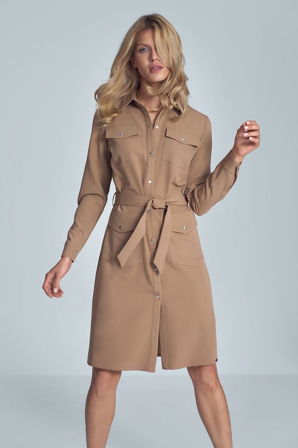 Elegant beige midi shirt dress featuring long sleeves, a fabric belt tie at the waist, and four buttoned patch pockets at the front. The snap fastener adds a stylish touch, making this dress perfect for both casual and semi-formal occasions.