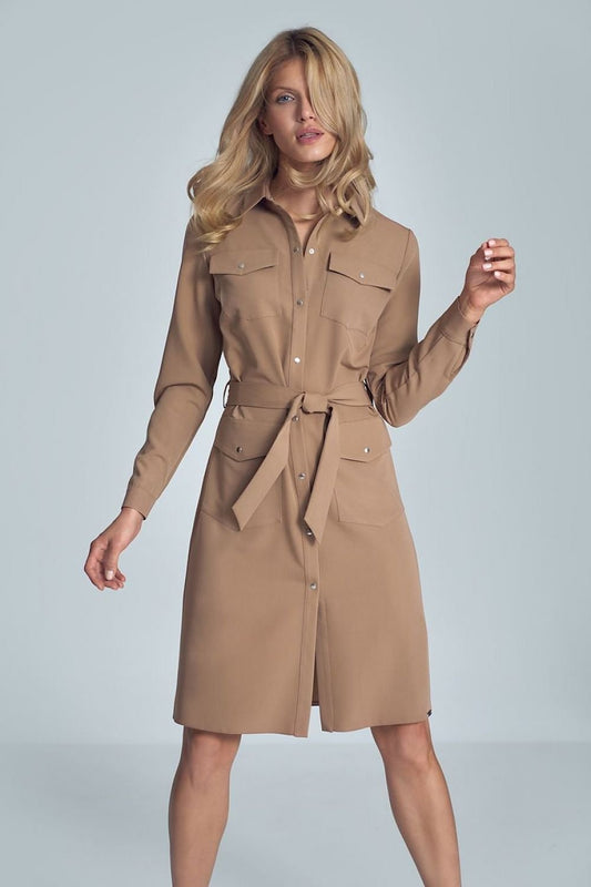 Elegant beige midi shirt dress featuring long sleeves, a fabric belt tie at the waist, and four buttoned patch pockets at the front. The snap fastener adds a stylish touch, making this dress perfect for both casual and semi-formal occasions.