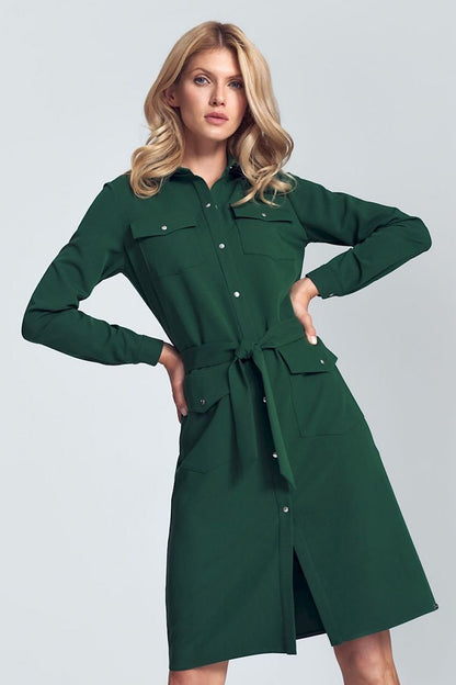 Elegant green midi shirt dress featuring long sleeves, a fabric belt tie at the waist, and four buttoned patch pockets at the front. The snap fastener adds a stylish touch, making this dress perfect for both casual and semi-formal occasions.