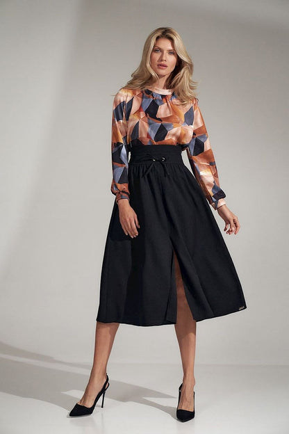 Blouse with a stand-up collar featuring a delicate crease under the neck, geometric patterns, long creased sleeves with cuffs, and a covered zip fastening at the back.