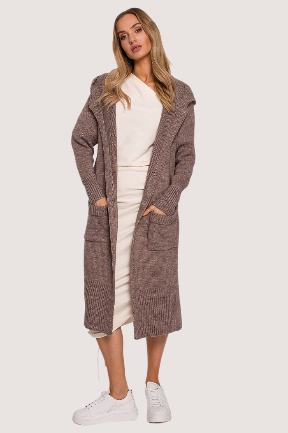 A cozy, coat-like cardigan made from soft yarn, featuring a large, fitted hood, two large front pockets with tabs, and decorative slits on the sides. Unbuttoned design for a relaxed, stylish look.