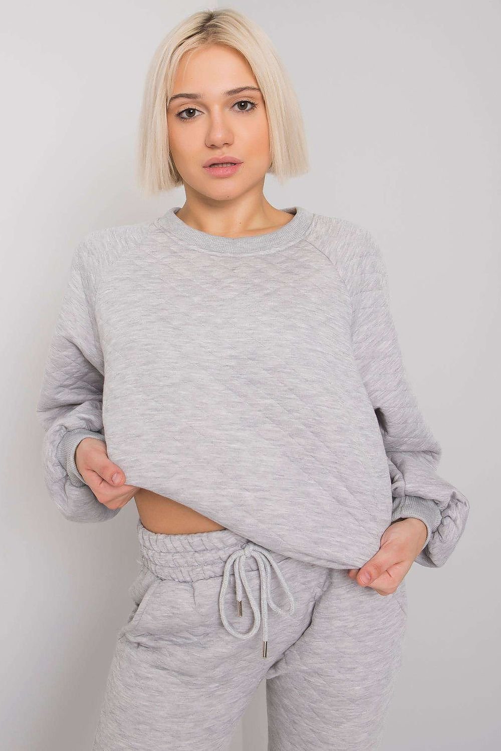 Cozy quilted tracksuit set featuring a long-sleeve sweatshirt without a hood, paired with sweatpants that have a waist tie and slip pockets. Ideal for casual outings or lounging, this set offers comfort and warmth with a stylish design.