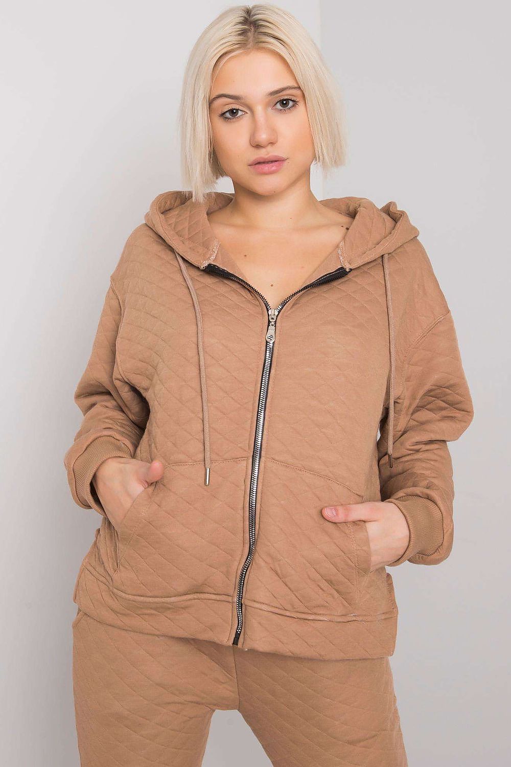 A women's sweatshirt made from quilted fabric, featuring a hood, a zip closure, and convenient slip pockets at the front for a cozy and stylish look. Ideal for casual wear.






