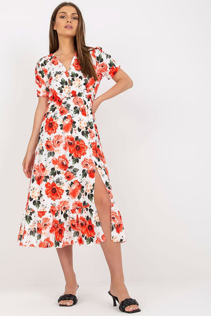 A breezy summer dress in vibrant floral fabric, featuring short sleeves, front buttons, a chic slit at the bottom, and a playful frill detail, perfect for warm sunny days.


