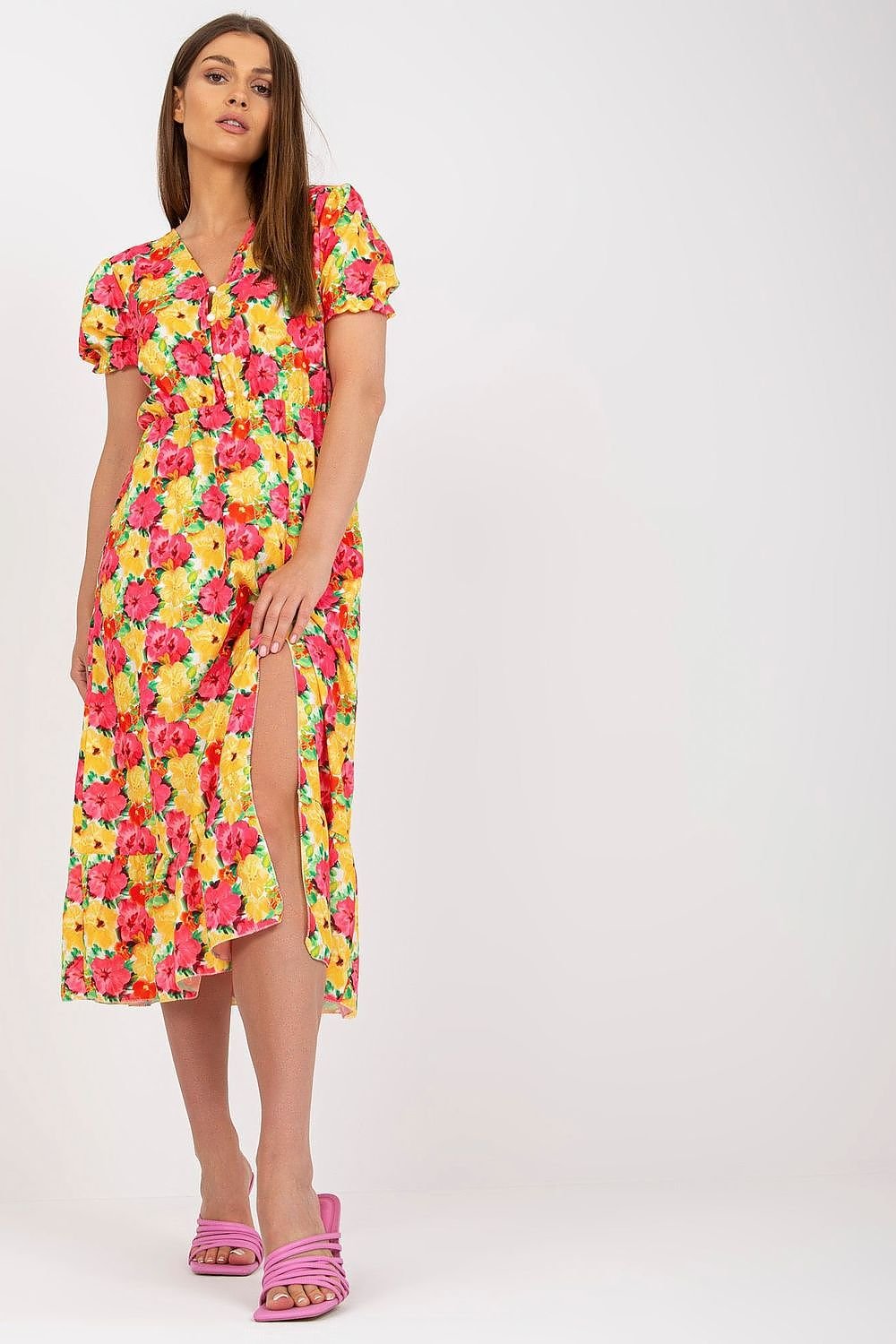 A breezy summer dress in vibrant floral fabric, featuring short sleeves, front buttons, a chic slit at the bottom, and a playful frill detail, perfect for warm sunny days.


