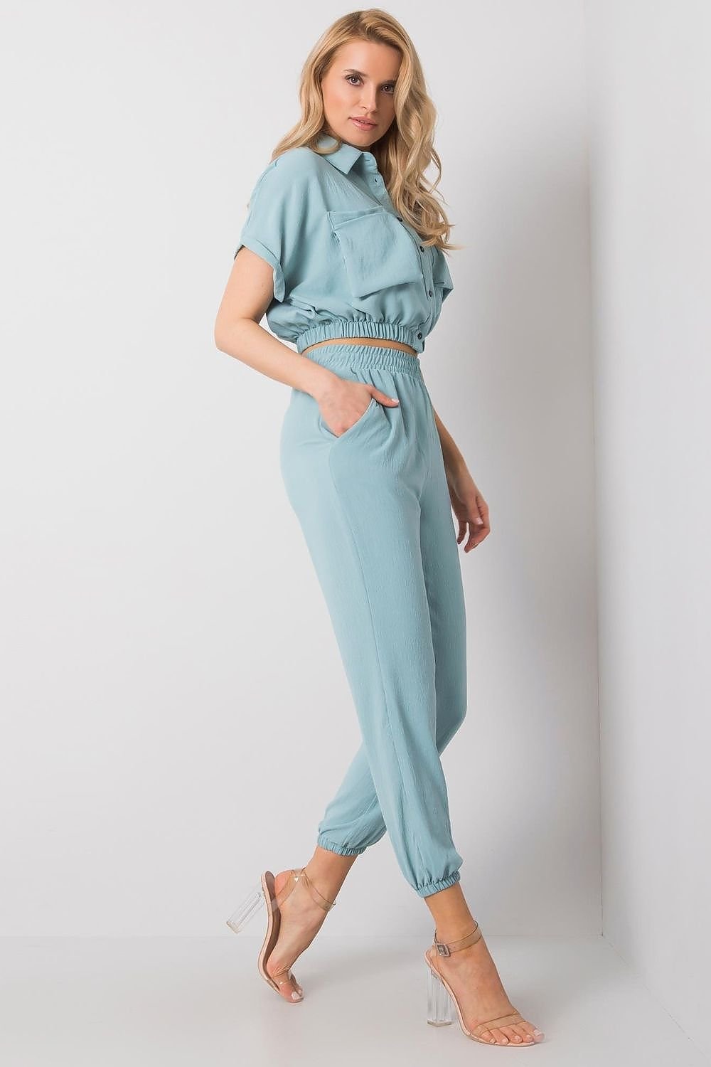 Women's set featuring a buttoned short-sleeve blouse and long pants with an elastic waistband and slip pockets. A comfortable and stylish combination for everyday wear.






