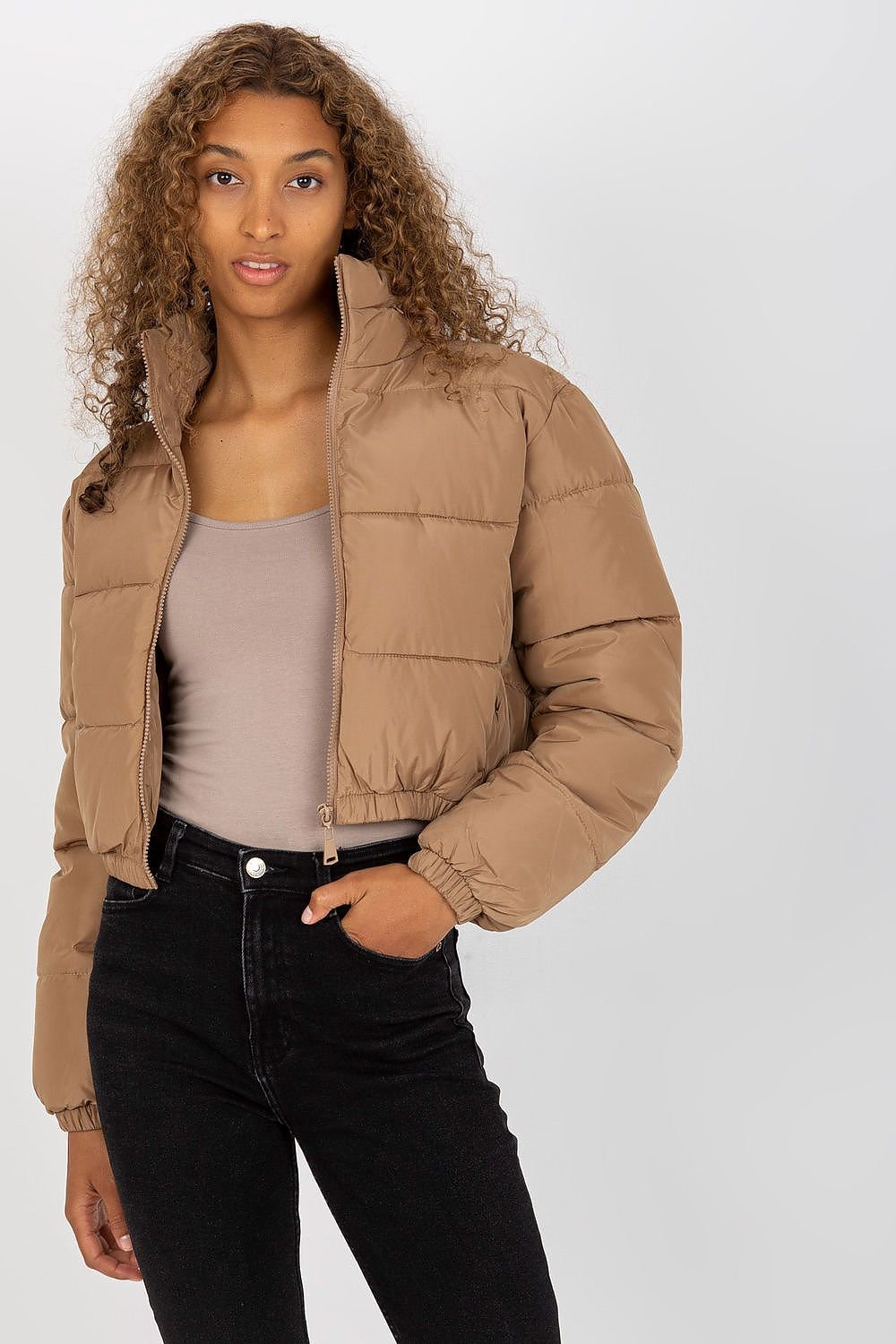 A short quilted jacket with a zip closure, long sleeves, and side slip pockets. Fully lined for added comfort, it features a non-removable hood discreetly tucked into the collar, combining practicality with style.