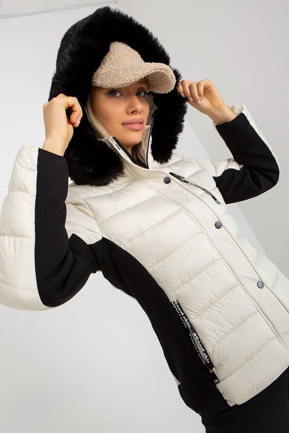 A stylish quilted down jacket with long sleeves, a zip and press-stud closure, and zippered pockets. Fully lined for warmth, it features a detachable hood with decorative fur, offering both functionality and elegance.