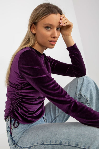 Stylish short velour blouse with long sleeves, round neckline, and adjustable side ties for a customizable fit.