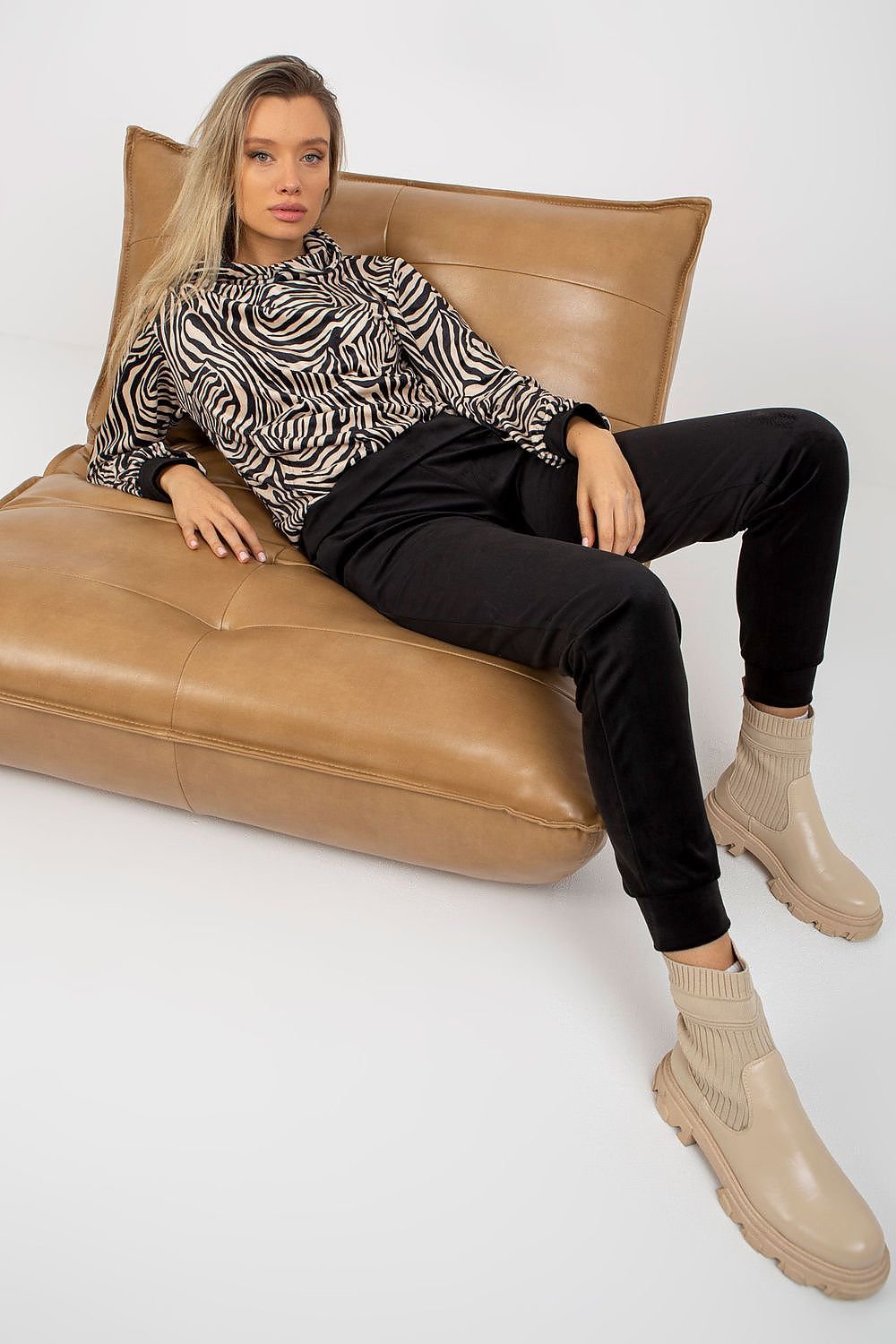 A comfortable velour set featuring a hooded sweatshirt with animal print and a kangaroo pocket, paired with long pants with slip pockets, offering a stylish and casual look.