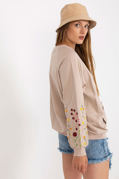 A women's sweatshirt featuring long sleeves, a kangaroo pocket, and decorative embroidery on the sleeves, offering both comfort and style.






