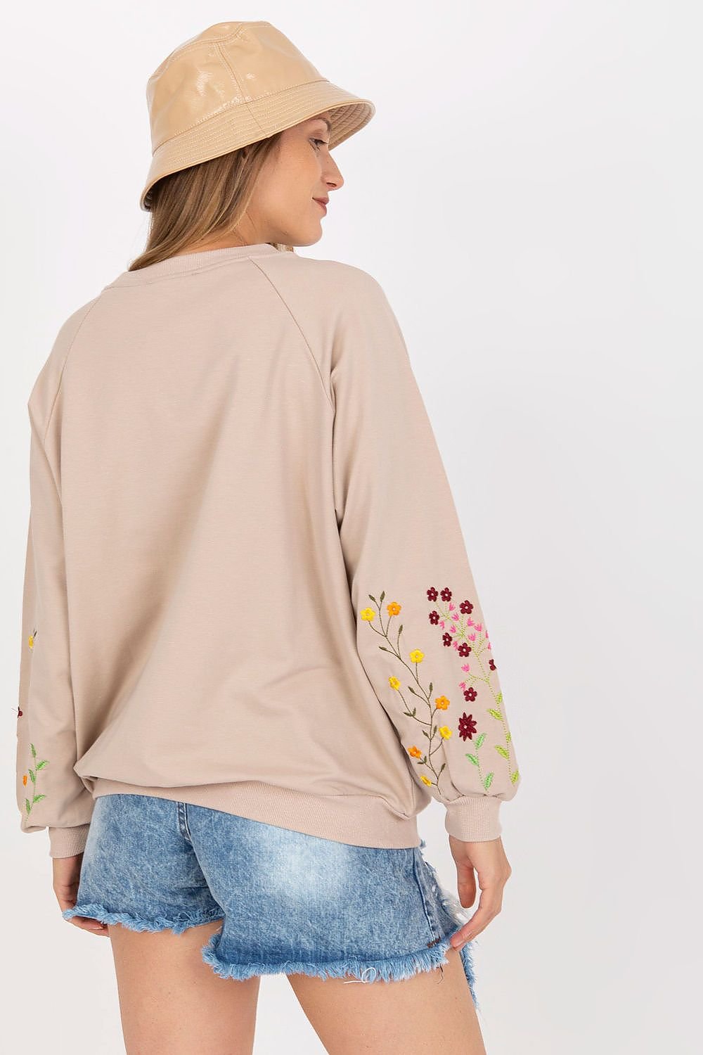 A women's sweatshirt featuring long sleeves, a kangaroo pocket, and decorative embroidery on the sleeves, offering both comfort and style.






