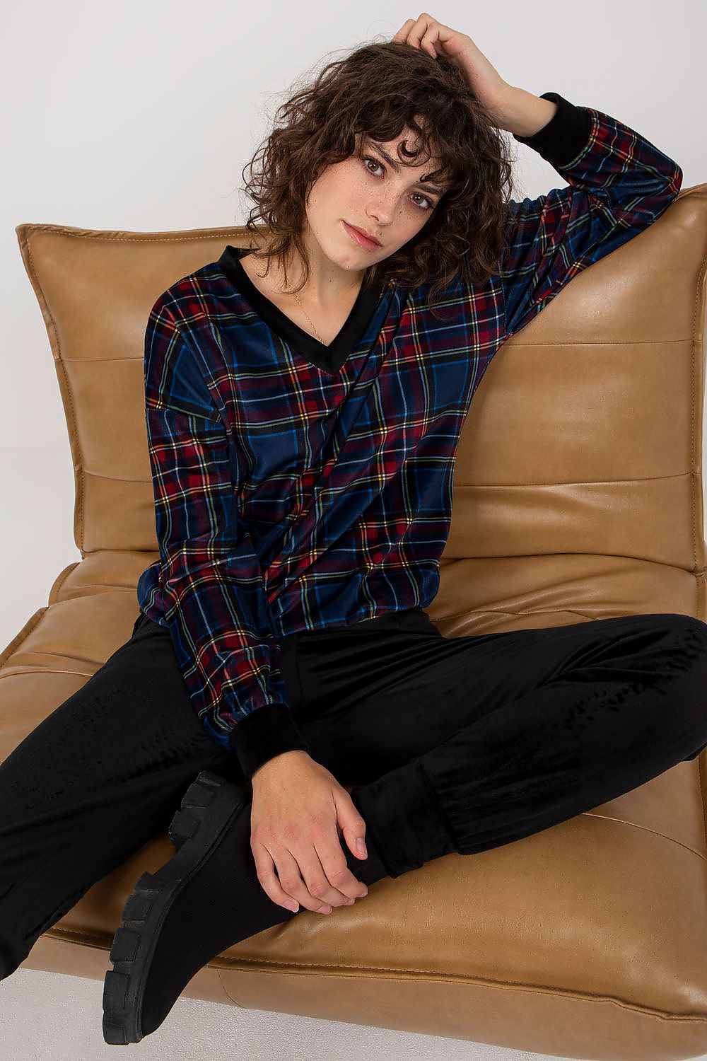 A chic velour set featuring a long-sleeved blouse with a checkered pattern, paired with black long pants with slip pockets, offering comfort and a stylish look.