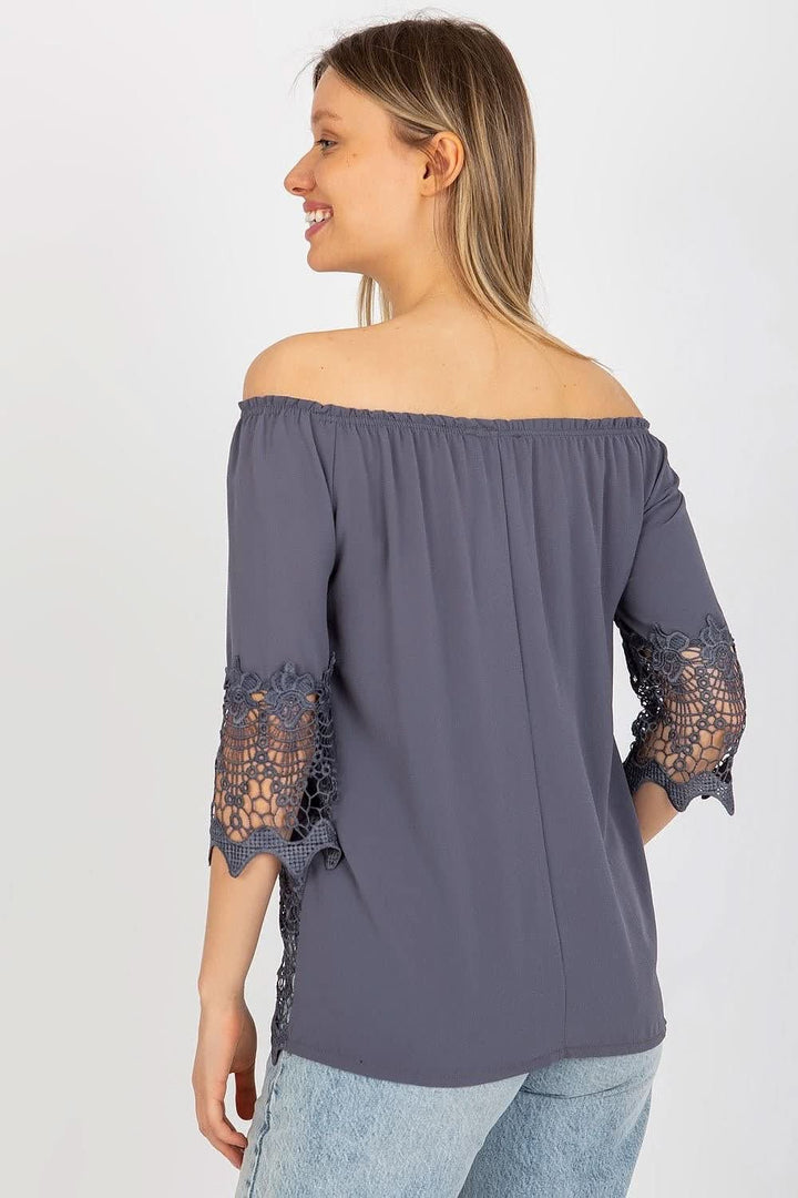 Elegant blouse with 3/4 sleeves, Spanish-style neckline, and decorative trim at the sleeves and bottom for a unique touch.