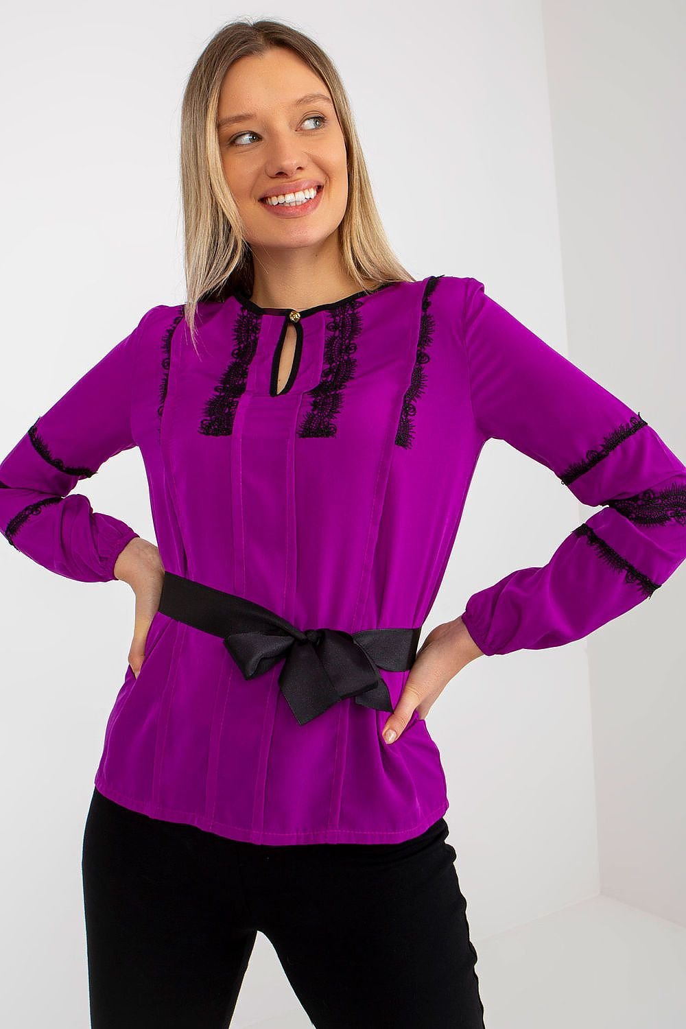 Elegant formal blouse with long sleeves, round neckline, sewn-on lace, and a tie belt, combining sophistication with comfort.