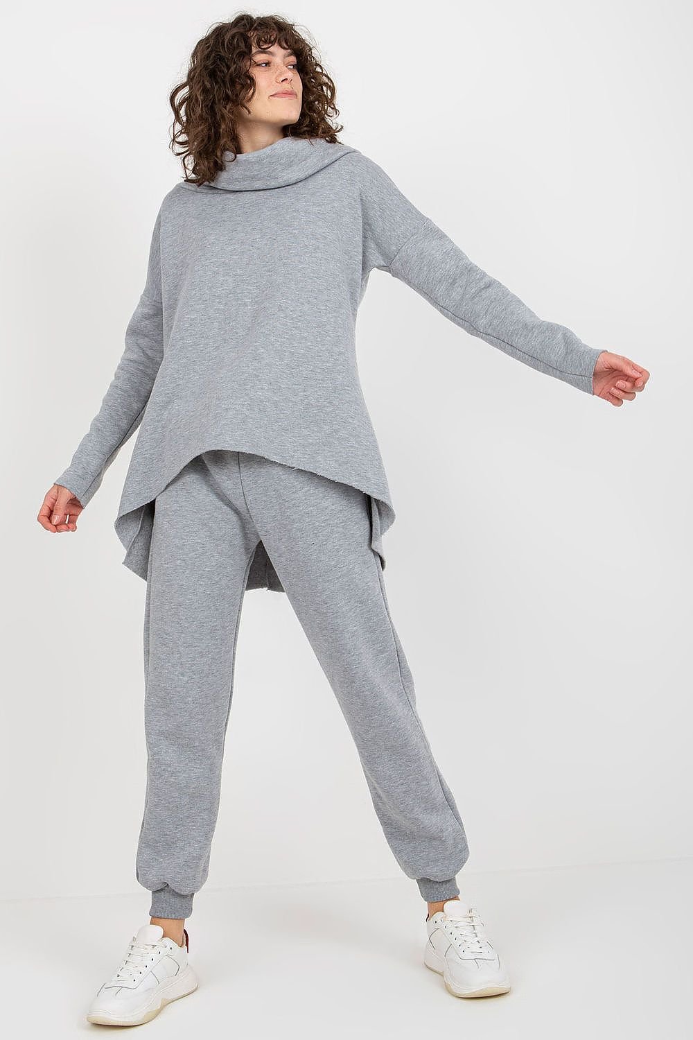 A women's set featuring an extended cut sweatshirt with long sleeves and a hood, paired with long pants that have a waist tie and pockets for added convenience.






