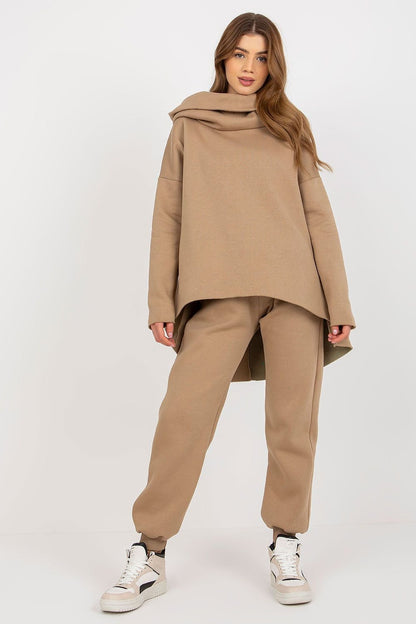 A women's set featuring an extended cut sweatshirt with long sleeves and a hood, paired with long pants that have a waist tie and pockets for added convenience.






