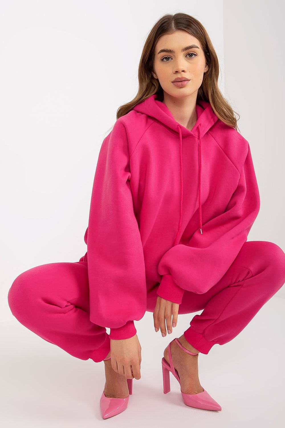 Casual and comfortable women's set featuring a sweatshirt with long sleeves and a hood, paired with pants that have a waist tie and slip pockets. Ideal for relaxed days, this set offers both style and practicality.