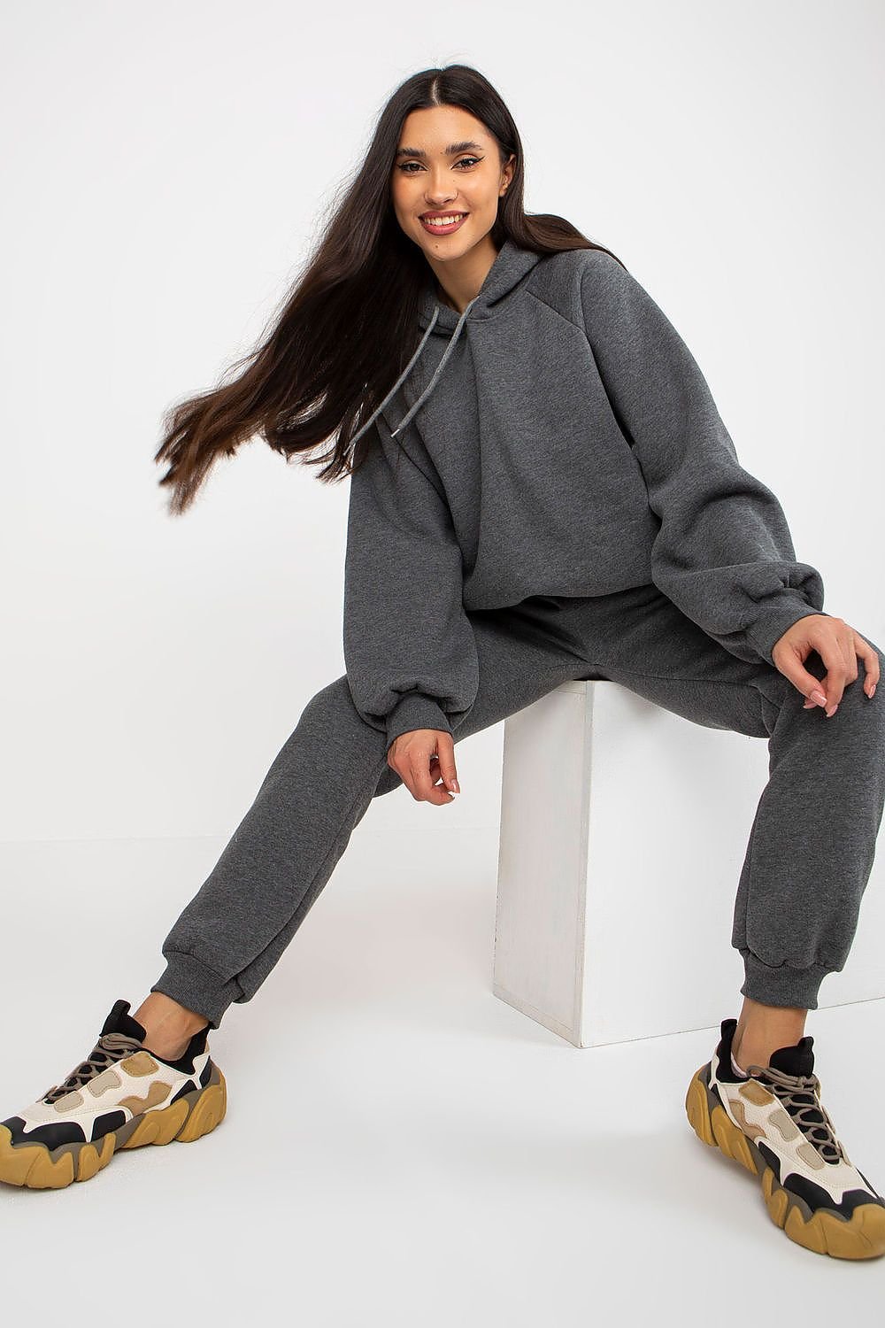 Casual and comfortable women's set featuring a sweatshirt with long sleeves and a hood, paired with pants that have a waist tie and slip pockets. Ideal for relaxed days, this set offers both style and practicality.