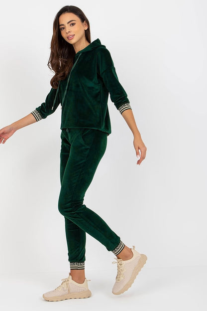 A stylish women's velour set featuring a hoodie with 3/4 sleeves, paired with long pants that have a waist tie and slip pockets. The set is finished with ribbed cuffs, adorned with a decorative print for added flair.


