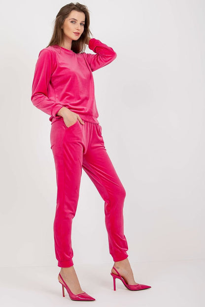 A ladies' velour set featuring a long-sleeve blouse that is tucked in over the head, paired with long pants with an elastic waistband and slip pockets on the sides for added convenience.






