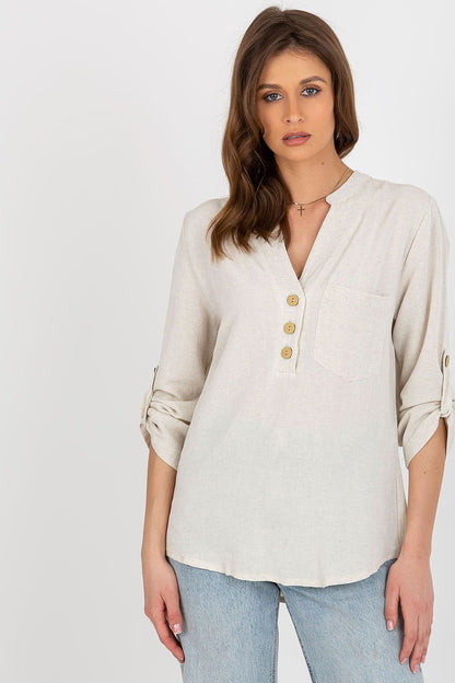 A shirt-like blouse with long sleeves, a heart-shaped neckline, and a decorative front clasp and pocket. Features sleeves with the option to roll up. Perfect for a variety of occasions.