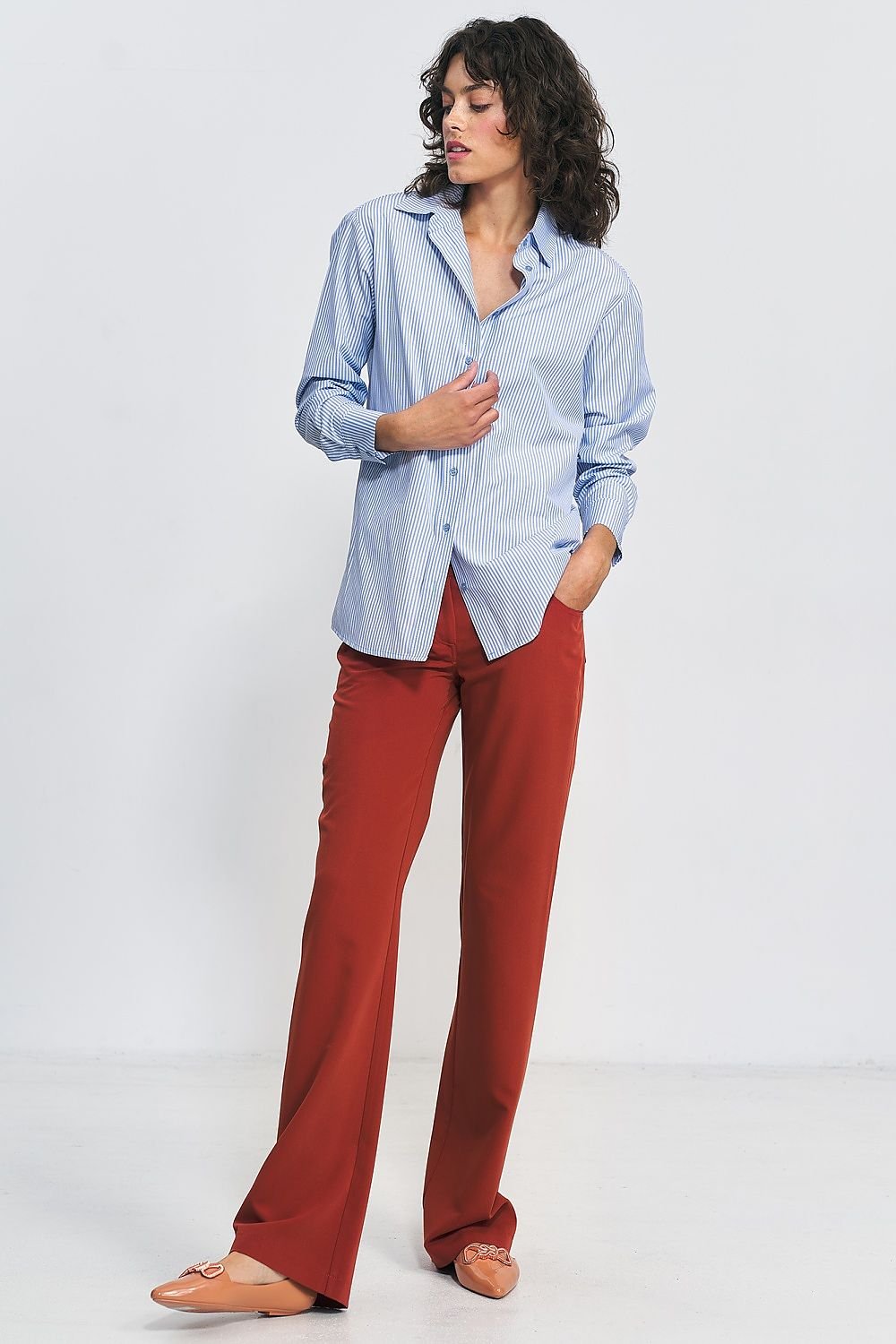 Bootcut red trousers designed for timeless elegance. Style them with heels for a sleek silhouette or pair them with a matching blazer for a polished office look. They also work effortlessly with casual sweaters and flats, making them a versatile wardrobe essential.






