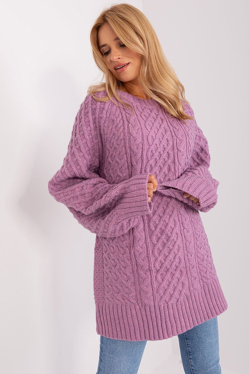 Comfortable oversized pink long sweater with a unique variegated fabric texture, made of soft acrylic for warmth, featuring long buff sleeves and a versatile design that can be worn as a short dress.






