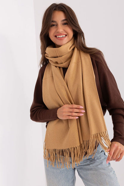 A cozy long beige scarf featuring decorative tassels, perfect for adding warmth and style to your winter wardrobe. Ideal for keeping you comfortable during colder months.






