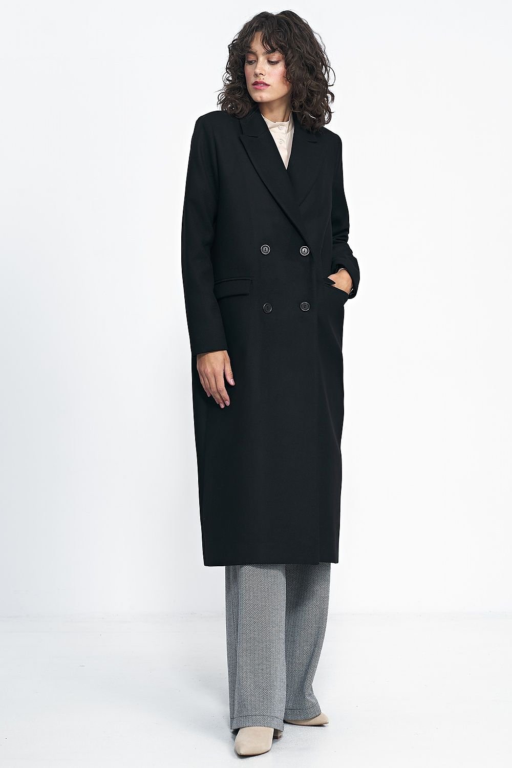 Oversized black double-breasted coat with an over-the-knee length, ideal for pairing with jeans or dresses.






